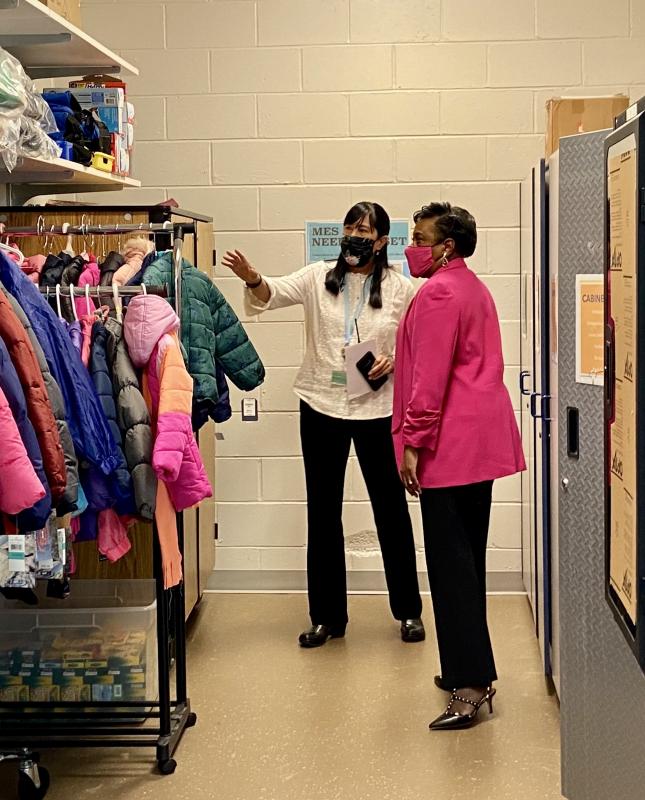 MES social worker Gloria Ho, left, shows NEA President Becky Pringle a sample of the clothes available to students through the Basic Needs Closet.
